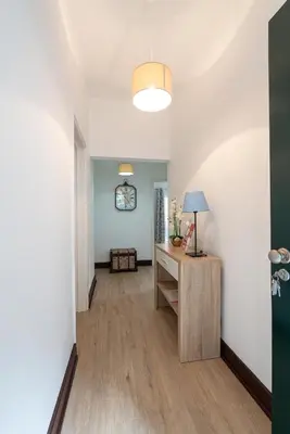 a hallway with a desk and a clock on the wall at VillaHouse in São Vicente