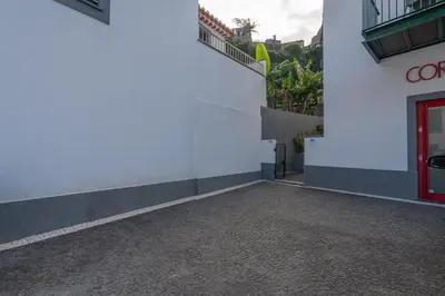 a white building with a red door on the side at VillaHouse in São Vicente