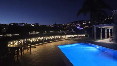a patio with a swimming pool and a lot of lights at Vivenda Por do Sol in Ponta do Sol
