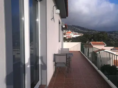 a balcony with chairs and tables on a building at Casa do Imaculado in Funchal