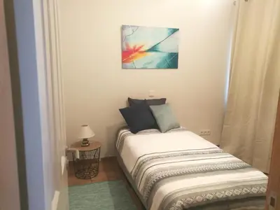 a small bed in a room with a painting on the wall at Casa do Imaculado in Funchal