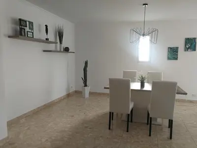 a dining room with a table and white chairs at Casa Vanday in Funchal