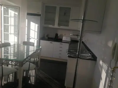 a kitchen with a glass table and white cabinets at Casa Vanday in Funchal