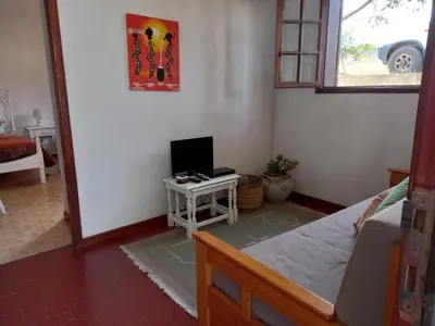 a bedroom with a bed and a desk with a computer at Quintinha das Lombas S in Porto Santo