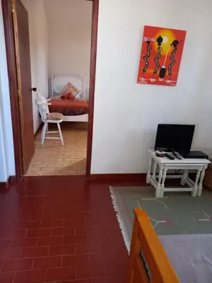 a room with a bed and a table with a laptop at Quintinha das Lombas S in Porto Santo