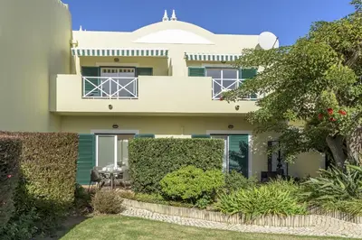 a house with a garden in front of it at FLH Praia da Luz Apartment with Pool in Alagoas