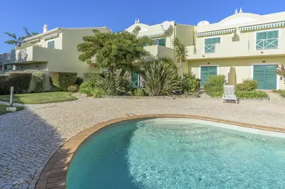 a house with a swimming pool in front of a house at FLH Praia da Luz Apartment with Pool in Alagoas