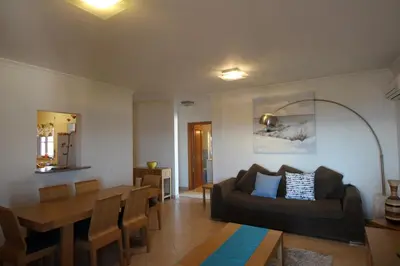 a living room with a couch and a table at Brisa Mar para 4 com piscina e WiFi in Luz