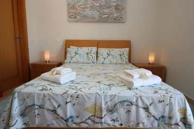 a bedroom with a bed with towels on it at Brisa Mar para 4 com piscina e WiFi in Luz