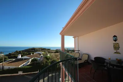 a balcony with a view of the ocean at Brisa Mar para 4 com piscina e WiFi in Luz