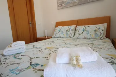 a bedroom with a bed with towels and two towels at Brisa Mar para 4 com piscina e WiFi in Luz