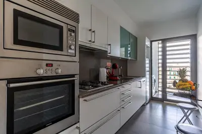 a kitchen with white cabinets and a microwave at Centromar Bella Vista by Atlantic Holiday in Funchal