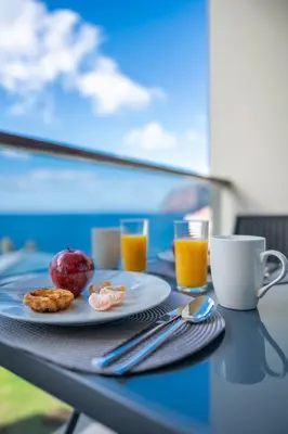 a table with a plate of food and orange juice at Centromar Bella Vista by Atlantic Holiday in Funchal