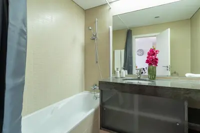 a bathroom with a tub and a sink and a mirror at Centromar Bella Vista by Atlantic Holiday in Funchal