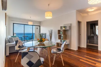 a living room with a glass table and chairs at Centromar Bella Vista by Atlantic Holiday in Funchal