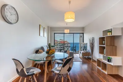 a dining room with a table and chairs and a clock at Centromar Bella Vista by Atlantic Holiday in Funchal