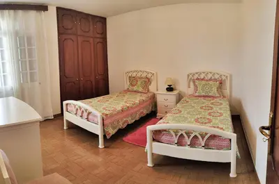 a bedroom with two beds and a cabinet at CASA Da CERCA ACHADA De GAULA in Santa Cruz
