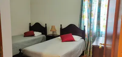 a bedroom with two beds with red pillows at CASA Da CERCA ACHADA De GAULA in Santa Cruz