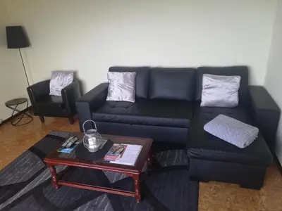 a living room with a black couch and a table at House Joel & Sonia with sea view in Funchal
