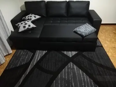 a black couch sitting in a living room with pillows at House Joel & Sonia with sea view in Funchal