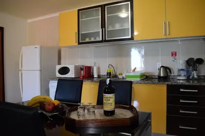 a kitchen with a table with a bottle of wine at Encanto do Sol in Ponta do Sol