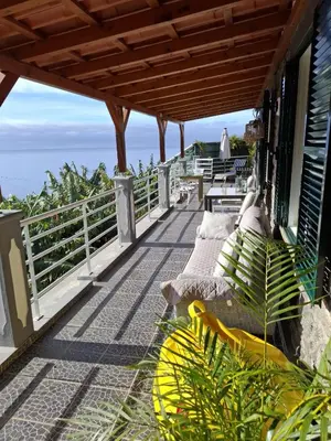 a balcony of a house with benches on it at Encanto do Sol in Ponta do Sol