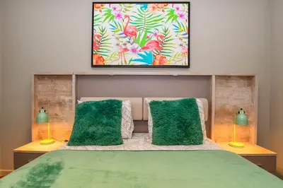 a bedroom with a green bed with two green pillows at Apartamento Boieiro Plaza in Caniço