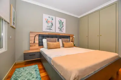 a bedroom with a large bed with a wooden headboard at Apartamento Boieiro Plaza in Caniço
