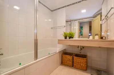 a bathroom with a shower and a tub and a sink at Apartamento Boieiro Plaza in Caniço
