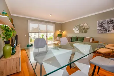 a living room with a glass table and chairs at Apartamento Boieiro Plaza in Caniço