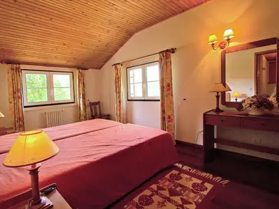 a bedroom with a red bed and a mirror at Quinta Das Colmeias Cottage in Santo da Serra