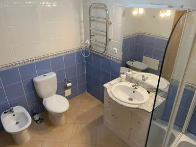 a blue and white bathroom with a toilet and a sink at St. James Beach & Pool Apartment in Luz