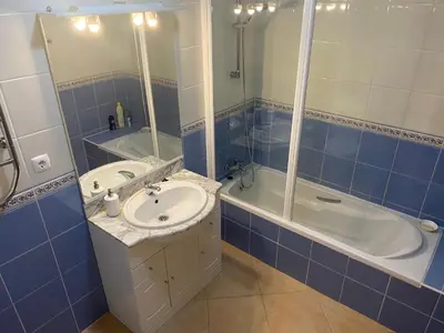 a blue tiled bathroom with a sink and a tub at St. James Beach & Pool Apartment in Luz