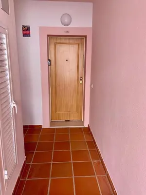 a hallway with a wooden door and a tiled floor at St. James Beach & Pool Apartment in Luz