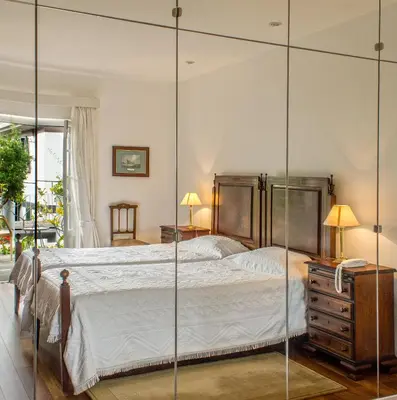a bedroom with a large bed with glass walls at Vila Vicência in Funchal
