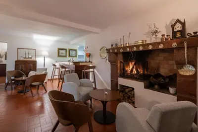a living room with a fireplace and chairs and a table at Vila Vicência in Funchal