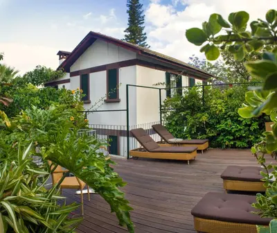 a deck with chairs and a house in the background at Vila Vicência in Funchal