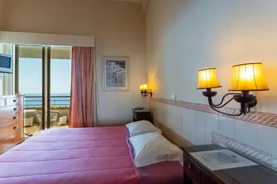 a hotel room with a bed and a view of the ocean at FLH Vivenda Belo Horizonte with Sea View in Caniço