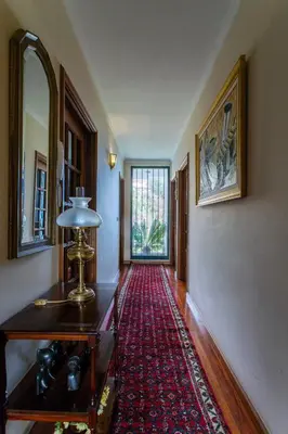 a hallway with a table and a red rug at FLH Vivenda Belo Horizonte with Sea View in Caniço