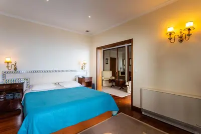 a bedroom with a bed with a blue blanket at FLH Vivenda Belo Horizonte with Sea View in Caniço