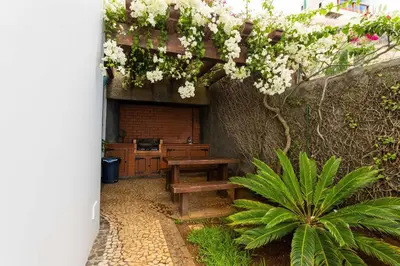 a patio with a wooden bench and flowers at FLH Vivenda Belo Horizonte with Sea View in Caniço