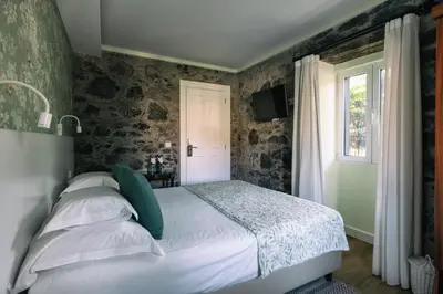 a bedroom with a bed and a window at Quinta da Saraiva in Câmara de Lobos