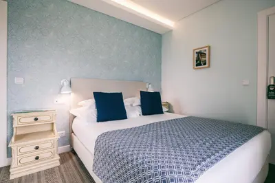 a bedroom with a large bed and a night stand at Quinta da Saraiva in Câmara de Lobos