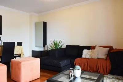 a living room with a black couch and a table at Perola, a Home in Madeira in Funchal