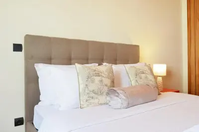 a white bed with white pillows and a headboard at Perola, a Home in Madeira in Funchal