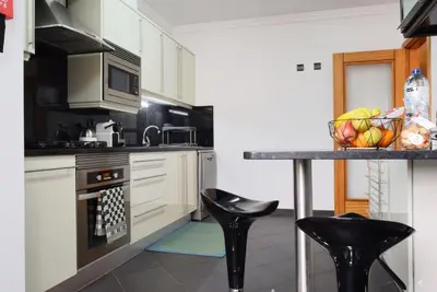 a kitchen with a counter and some stools in it at Perola, a Home in Madeira in Funchal