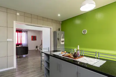 a kitchen with green walls and a counter top at Roraima House - Private Pool & Garden in Calheta