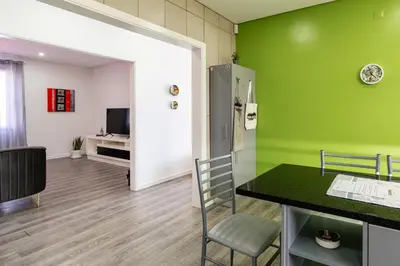 a room with a green wall and a table and chairs at Roraima House - Private Pool & Garden in Calheta