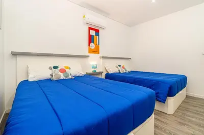 two beds in a room with blue sheets at Roraima House - Private Pool & Garden in Calheta