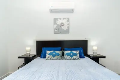 a bedroom with a blue bed with blue pillows at Roraima House - Private Pool & Garden in Calheta
